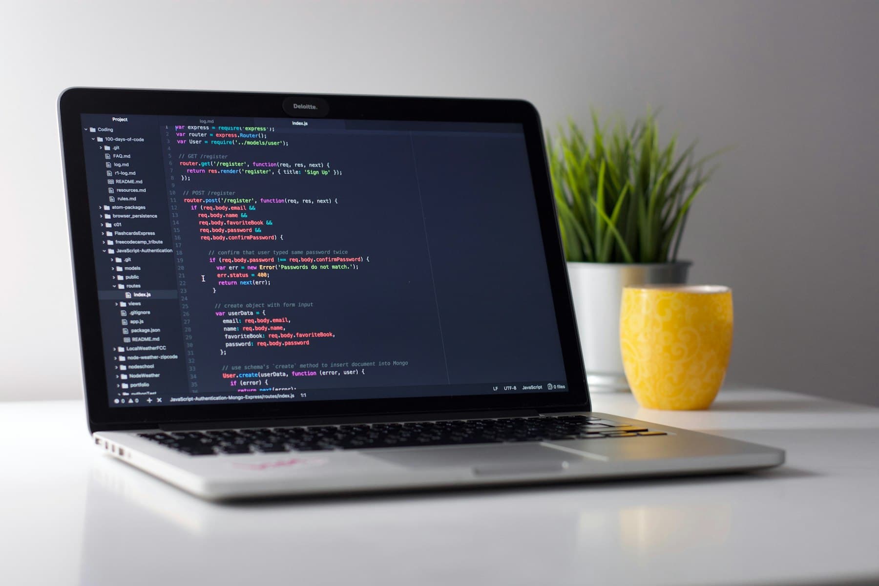 A developer working at a laptop with code on screen